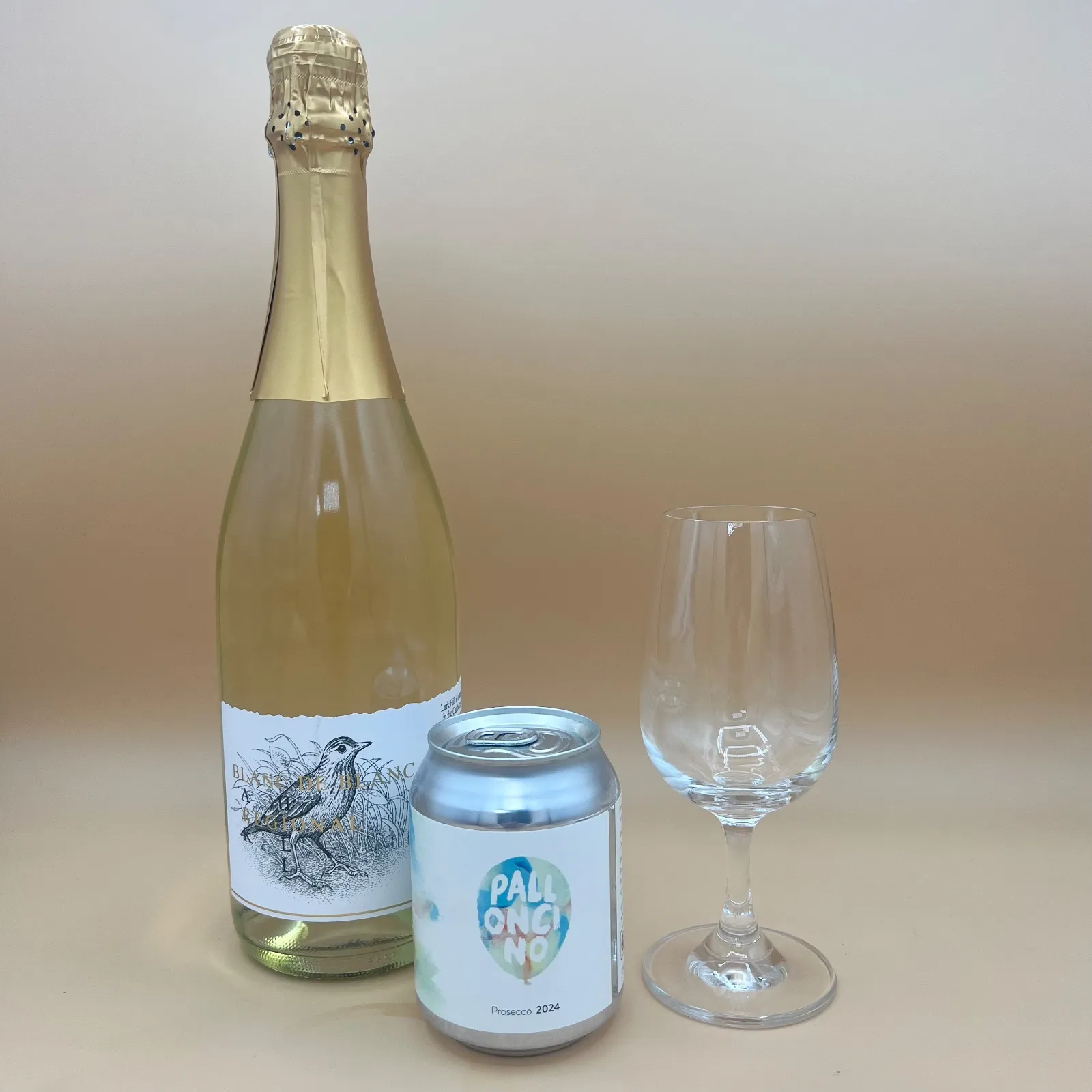 A bottle of sparkling wine, a can of sparkling wine, and a wine glass