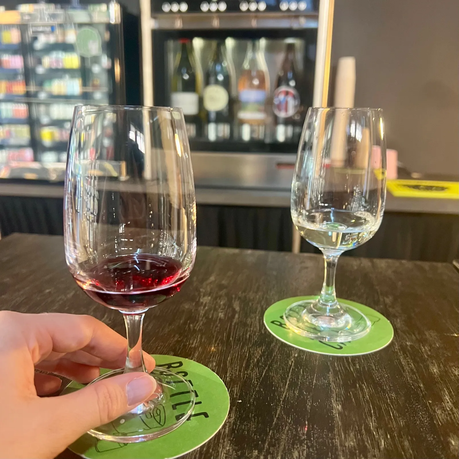 Red wine and white wine in wine glasses by a refrigerator